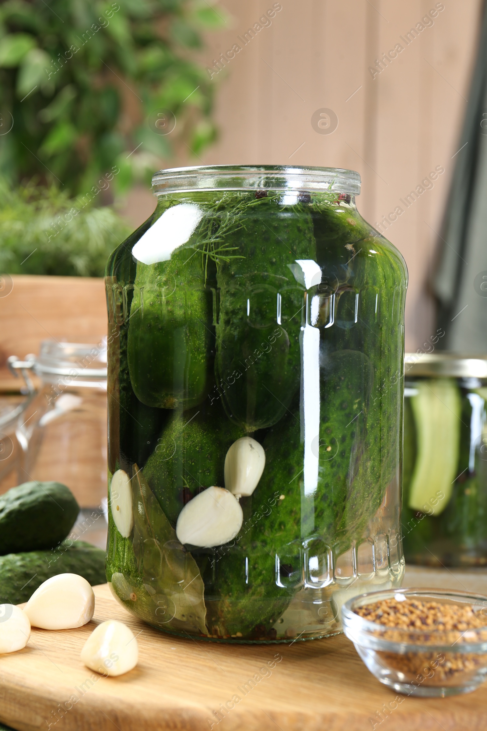 Photo of Making pickles. Fresh cucumbers and spices in jar on table