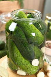 Making pickles. Fresh cucumbers and spices in jar on table, closeup