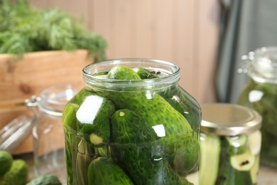 Photo of Making pickles. Fresh cucumbers in jar on table, closeup