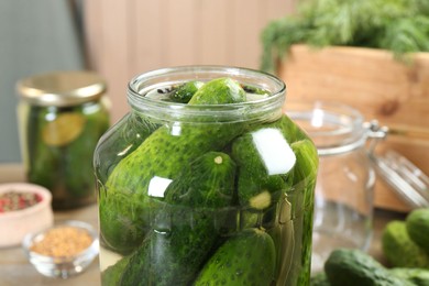 Photo of Making pickles. Fresh cucumbers in jar on table, closeup