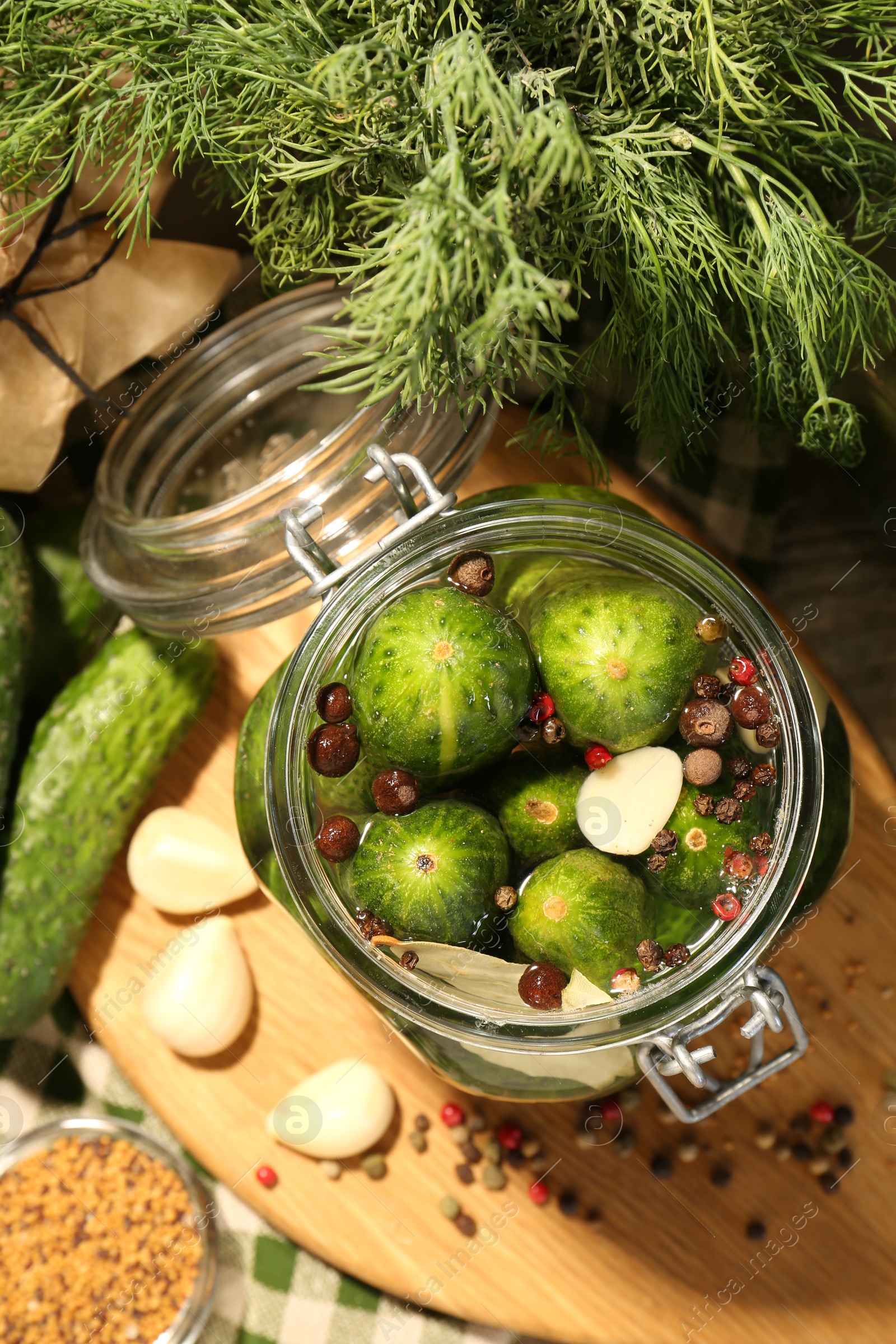 Photo of Making pickles. Fresh cucumbers and spices in jar on table, top view