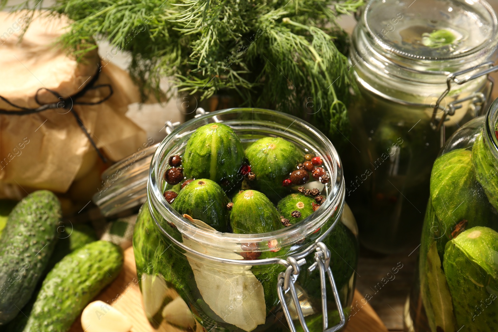 Photo of Making pickles. Fresh cucumbers and spices in jars on table, closeup