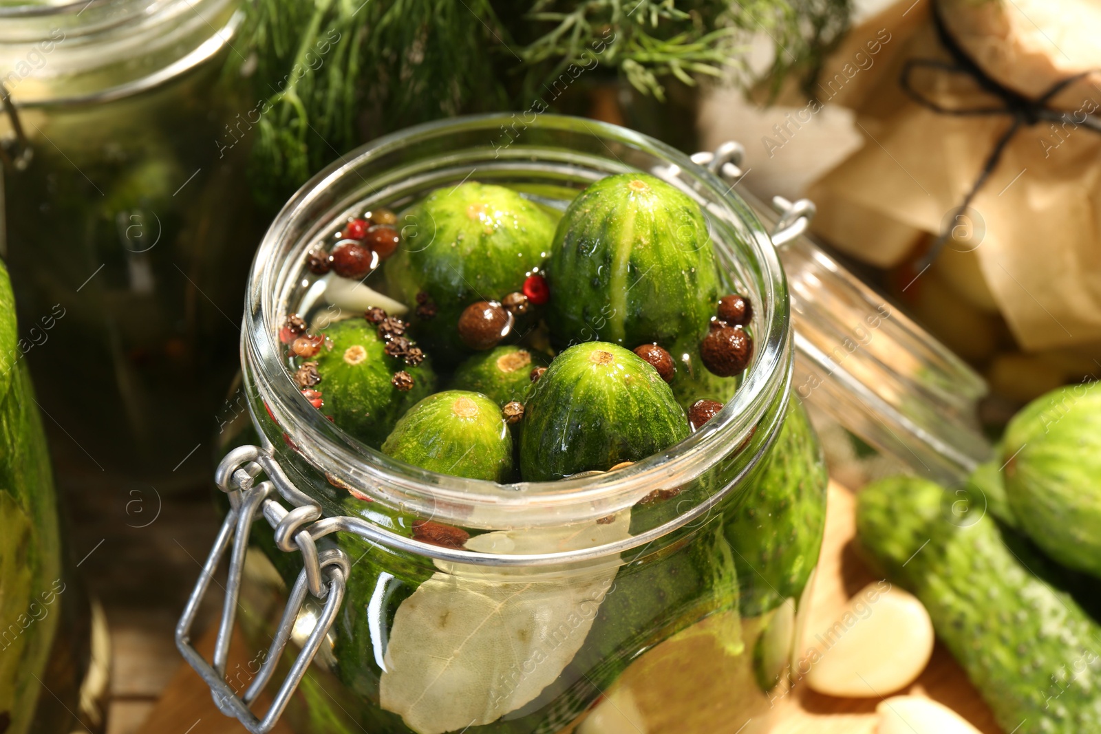 Photo of Making pickles. Fresh cucumbers and spices in jar on table, closeup