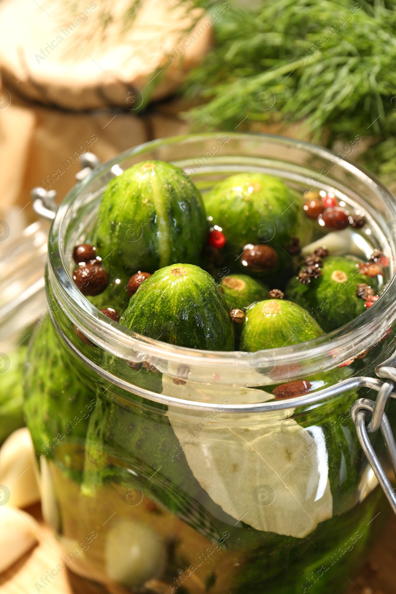 Photo of Making pickles. Fresh cucumbers and spices in jar on table, closeup