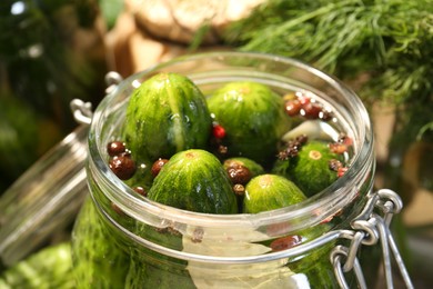 Photo of Making pickles. Fresh cucumbers and spices in jar on blurred background, closeup