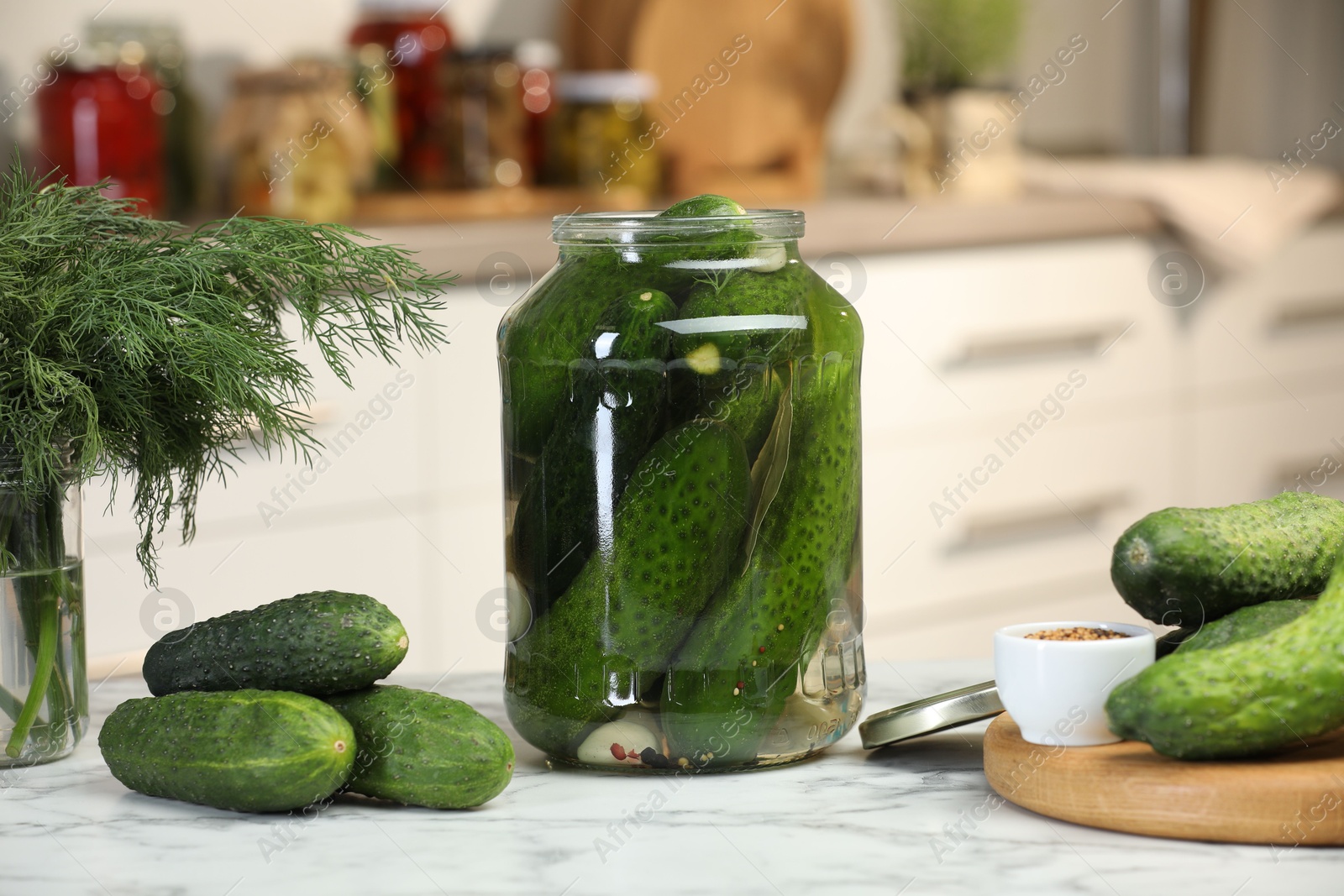 Photo of Making pickles. Fresh cucumbers and spices in jar on white marble table