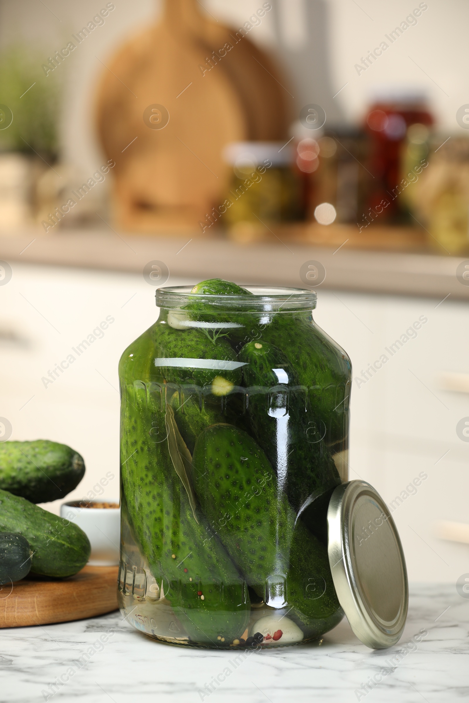 Photo of Making pickles. Fresh cucumbers and spices in jar on white marble table