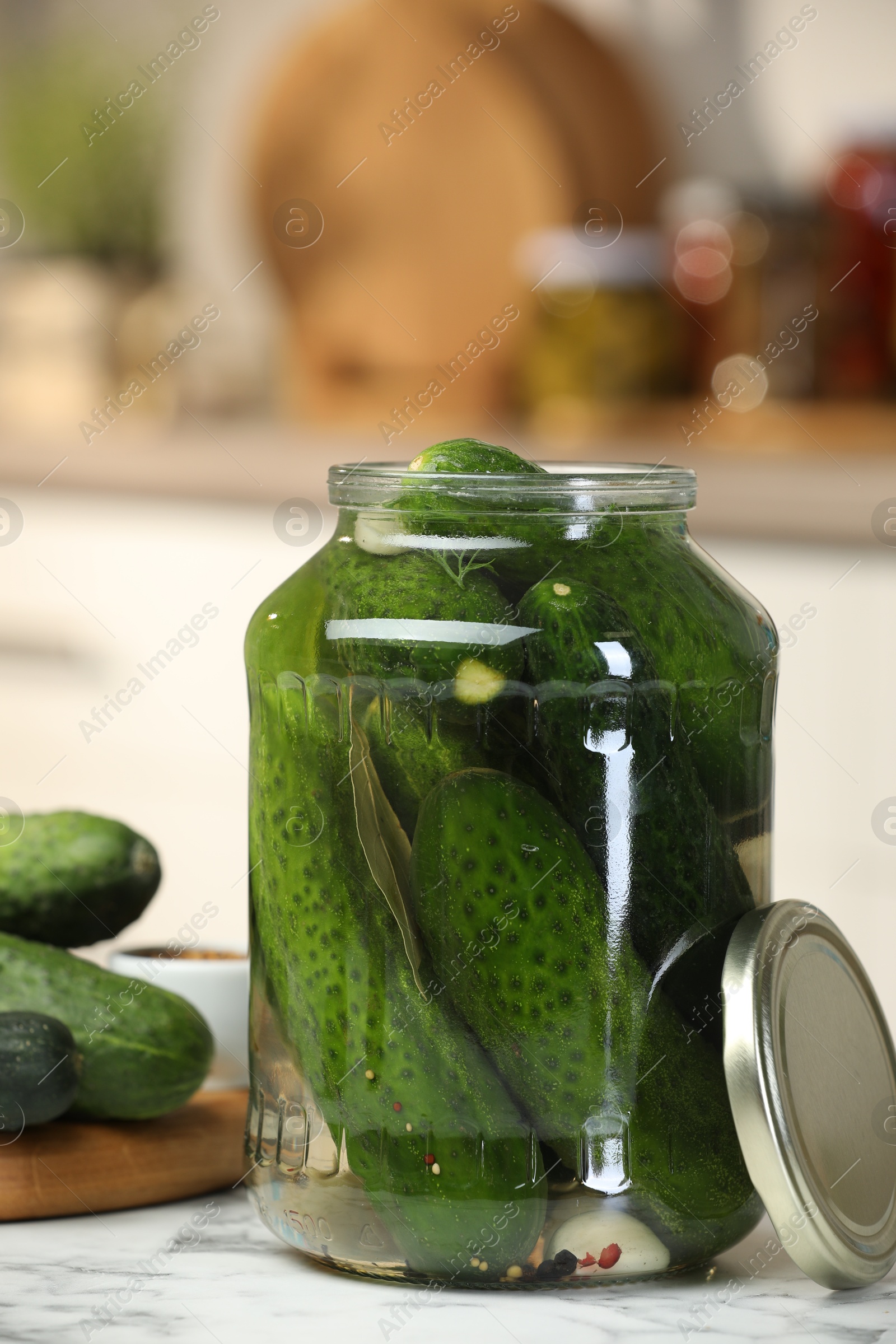 Photo of Making pickles. Fresh cucumbers and spices in jar on white marble table