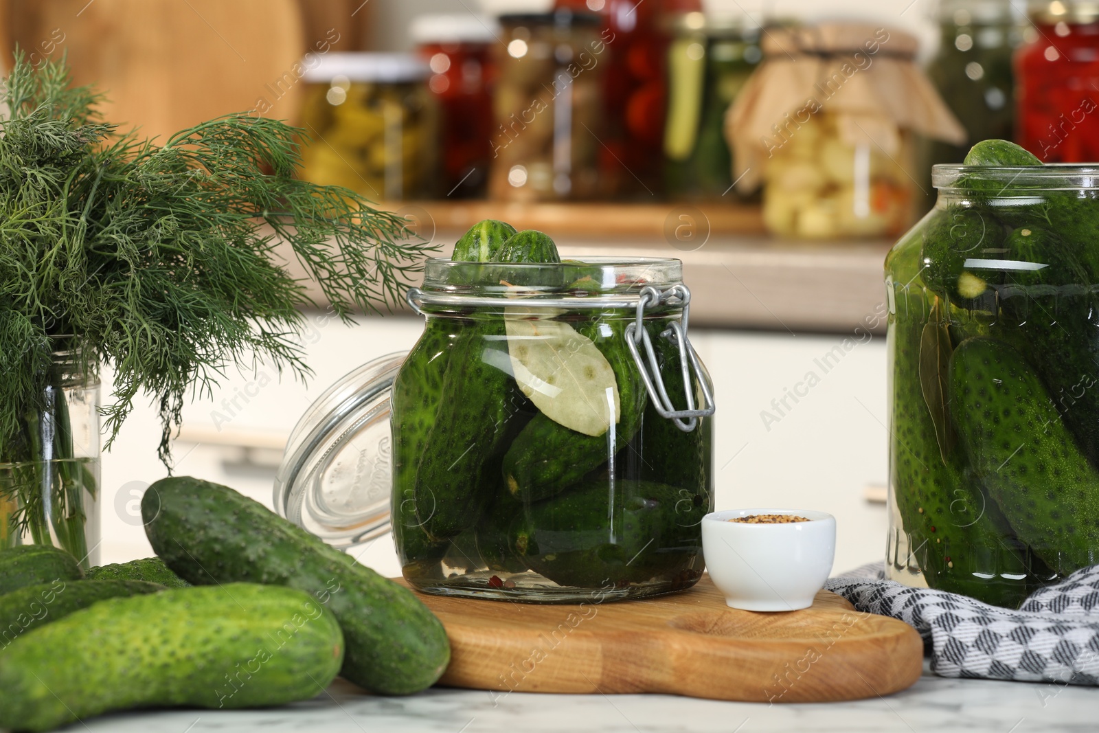 Photo of Making pickles. Fresh cucumbers and spices in jars on white marble table