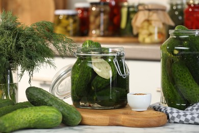 Photo of Making pickles. Fresh cucumbers and spices in jars on white marble table