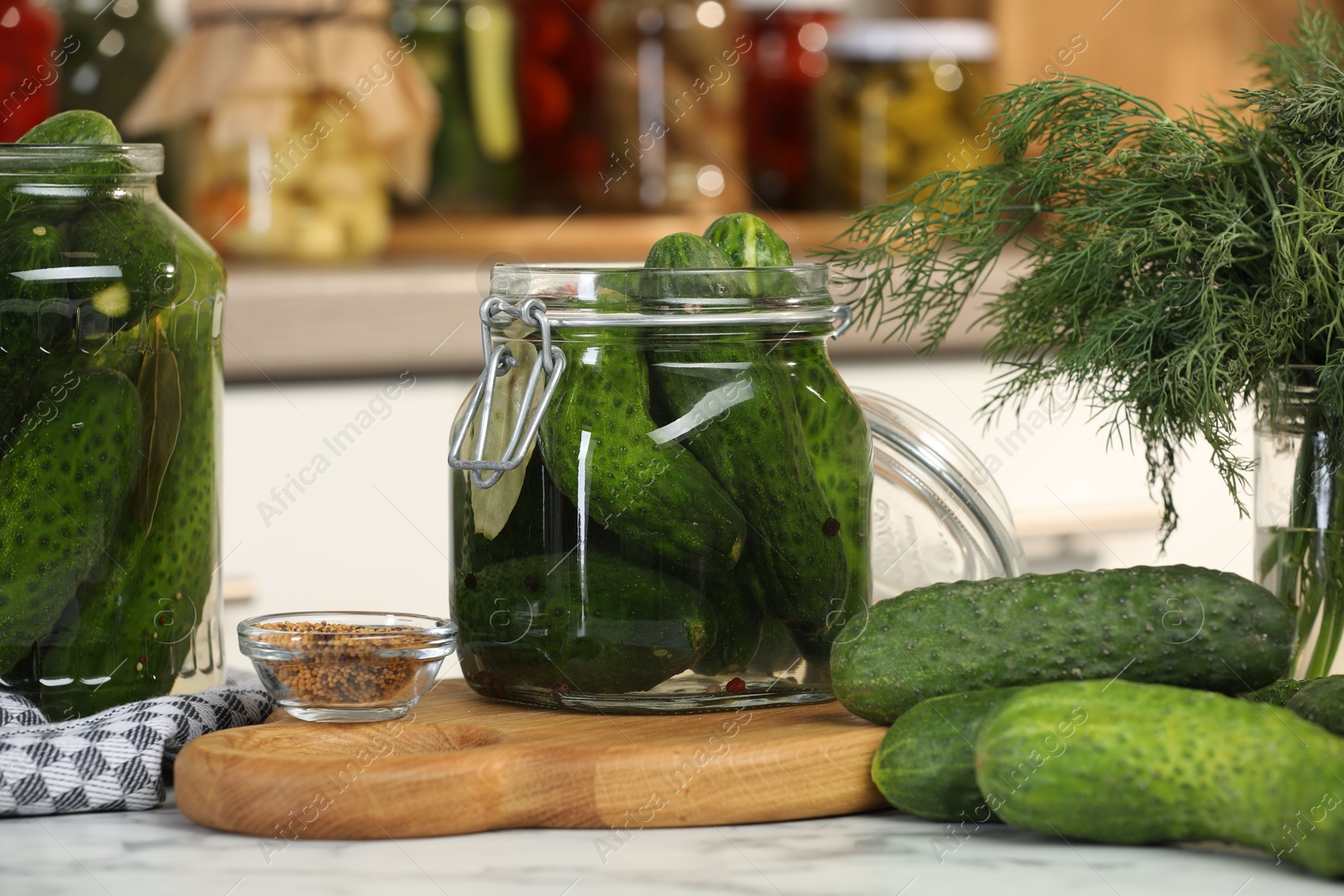 Photo of Making pickles. Fresh cucumbers and spices in jars on white marble table