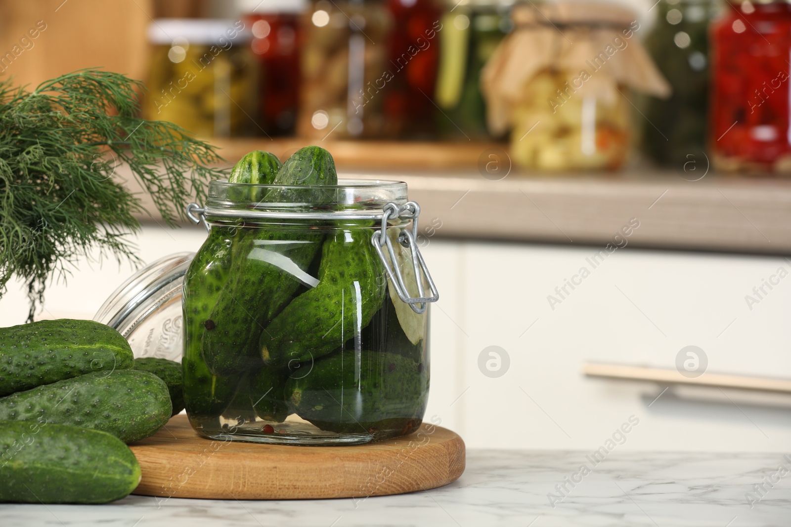 Photo of Making pickles. Fresh cucumbers and spices in jar on white marble table, space for text