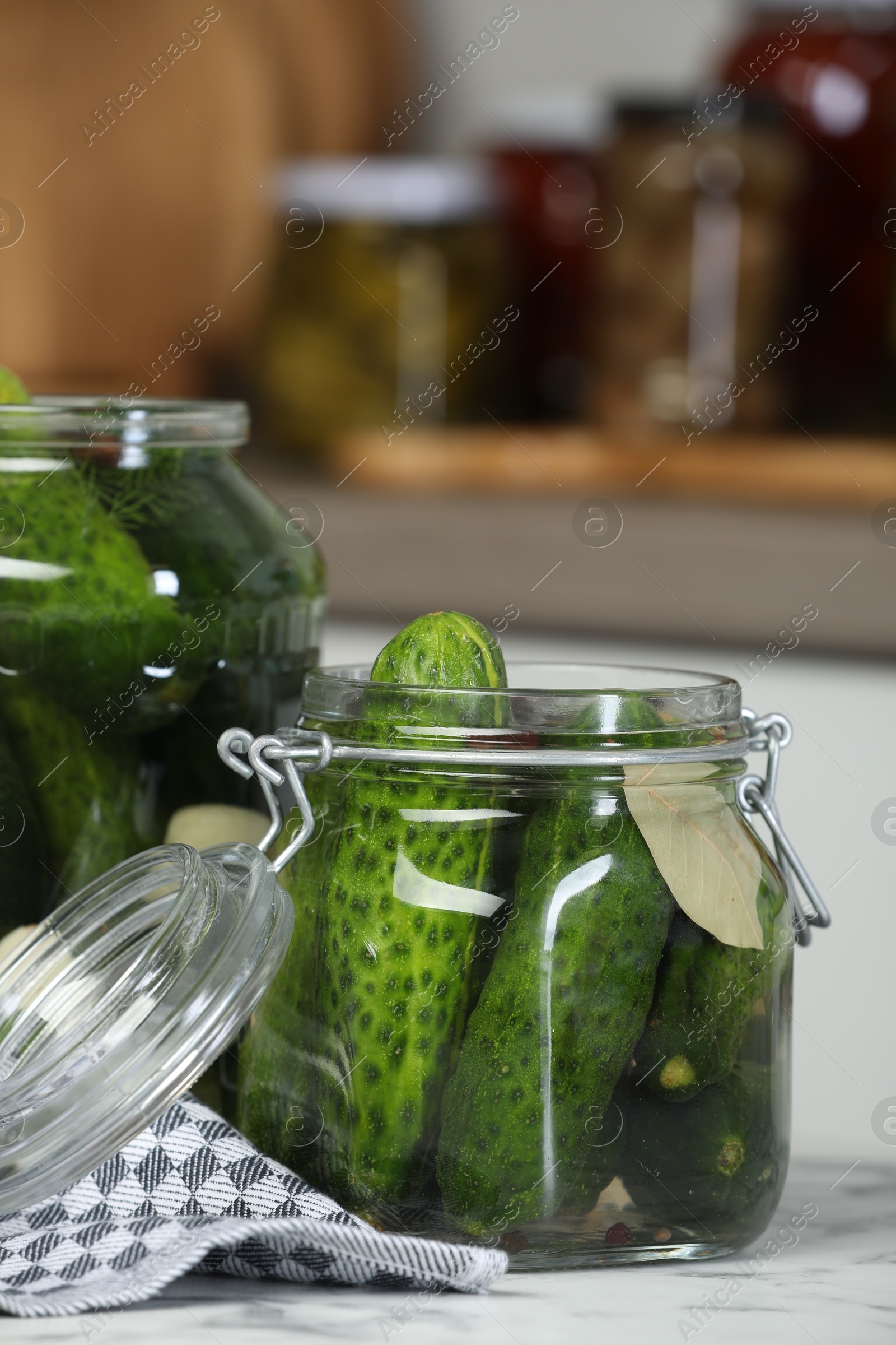 Photo of Making pickles. Fresh cucumbers and spices in jars on white marble table