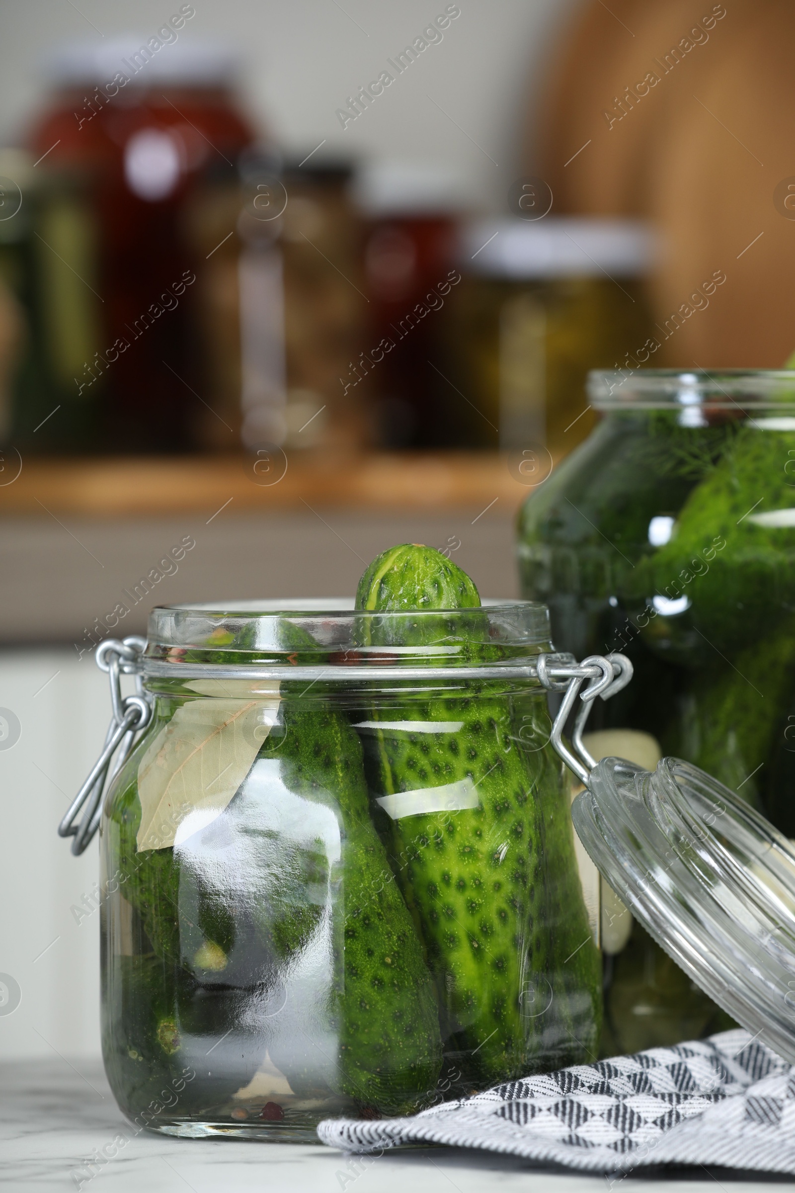 Photo of Making pickles. Fresh cucumbers and spices in jars on white marble table