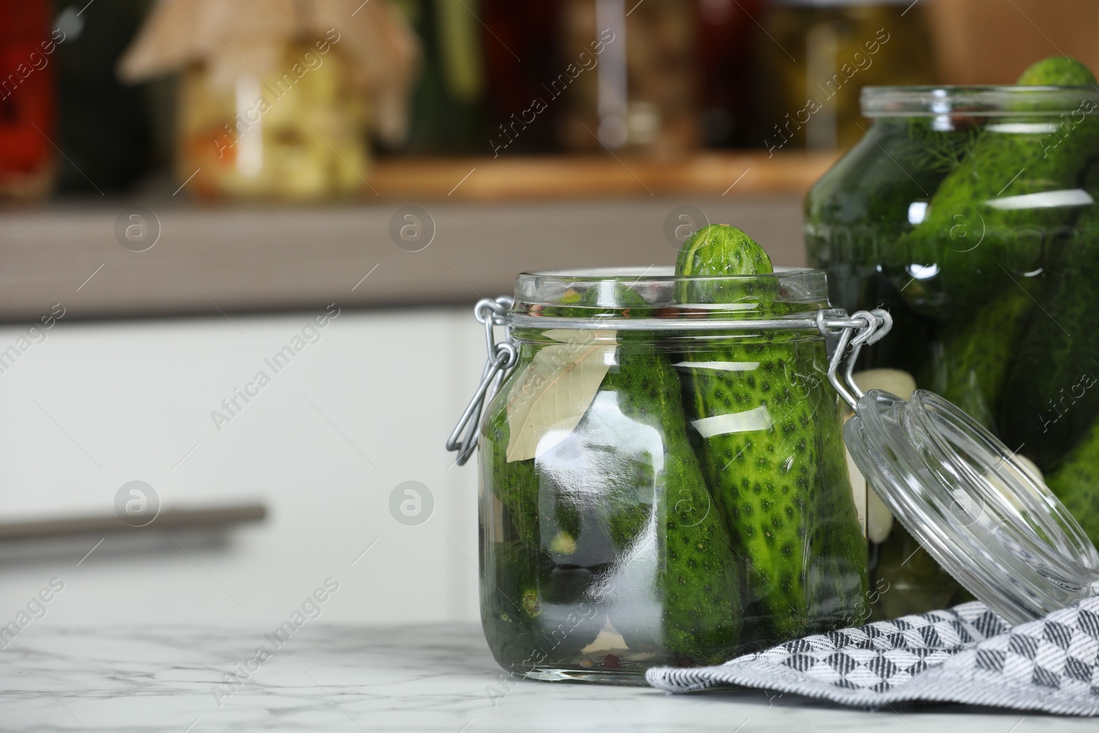 Photo of Making pickles. Fresh cucumbers and spices in jars on white marble table, space for text