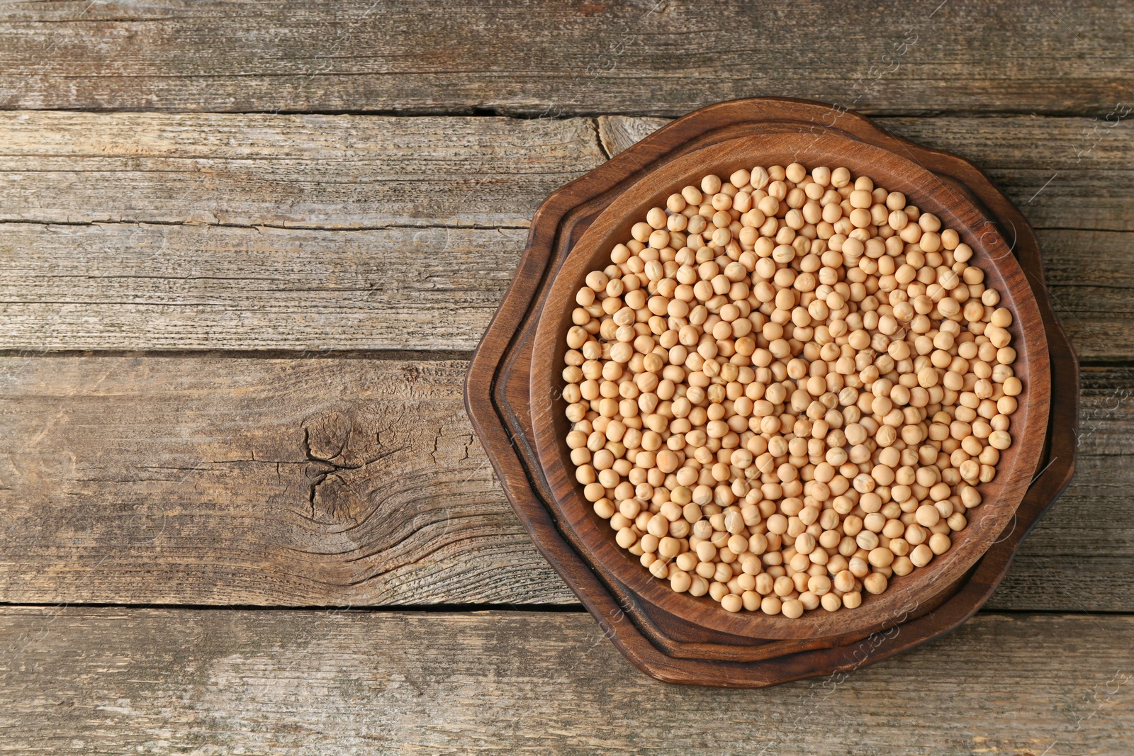 Photo of Dried peas on wooden table, top view. Space for text