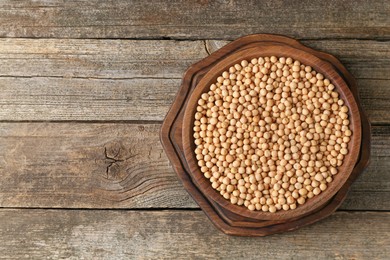 Photo of Dried peas on wooden table, top view. Space for text