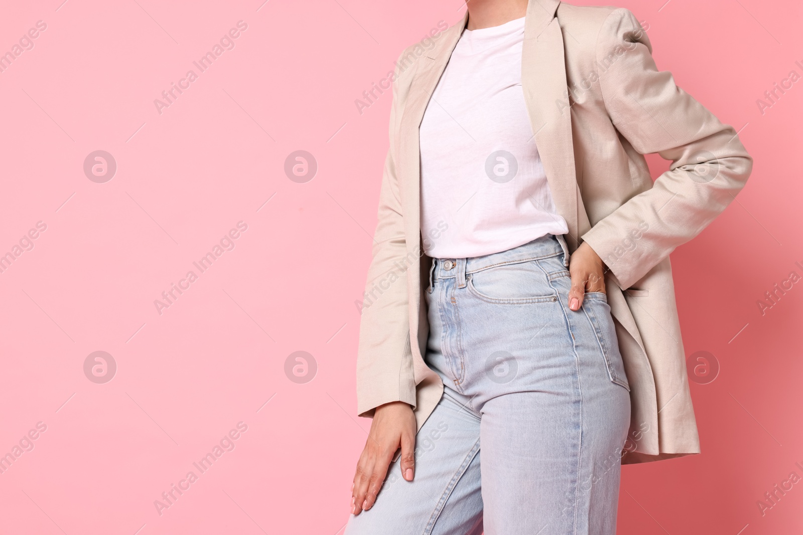 Photo of Woman in beige jacket and jeans on pink background, closeup. Space for text