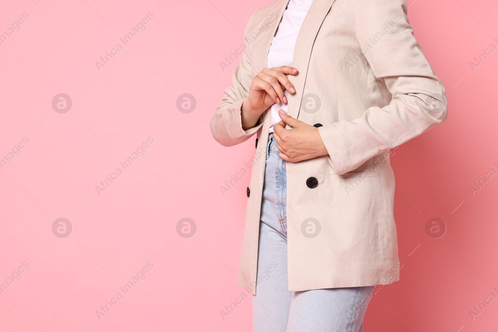 Photo of Woman in beige jacket and jeans on pink background, closeup. Space for text