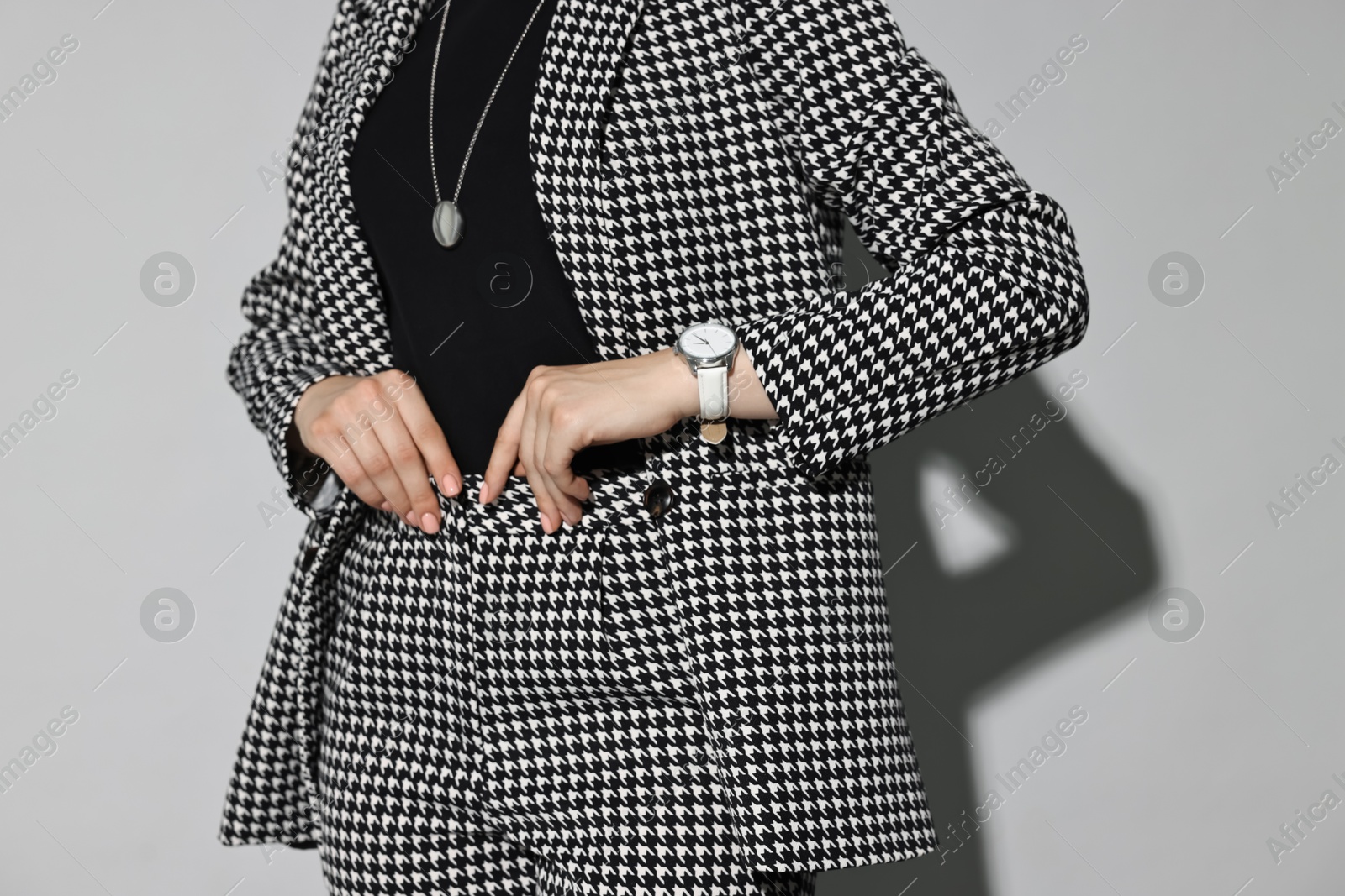 Photo of Woman in stylish suit on gray background, closeup