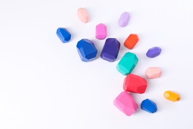 Many colorful balancing stones on white background, above view. Space for text