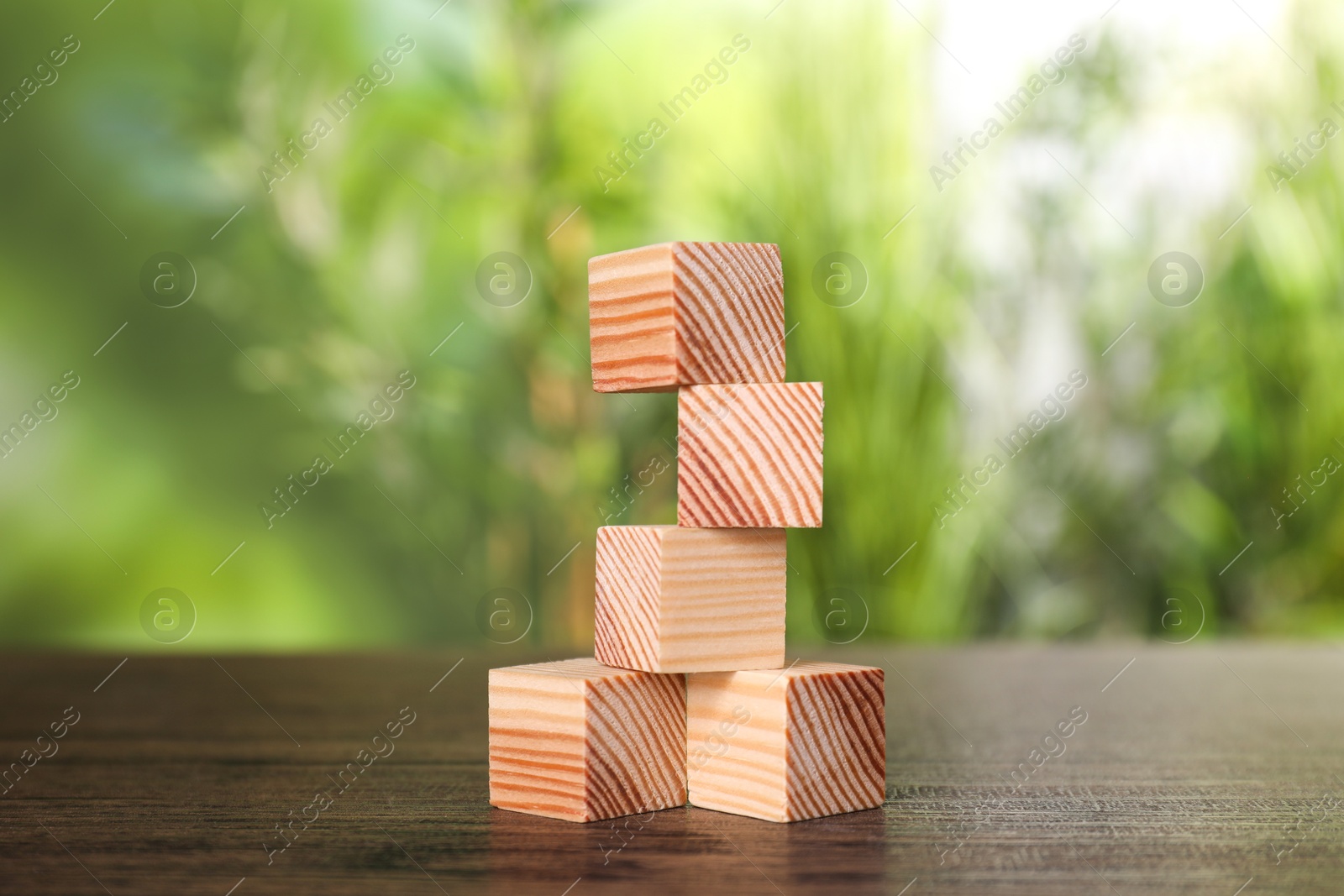 Photo of Many blank wooden cubes on table outdoors