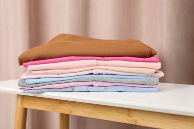 Stack of clothes on white table indoors