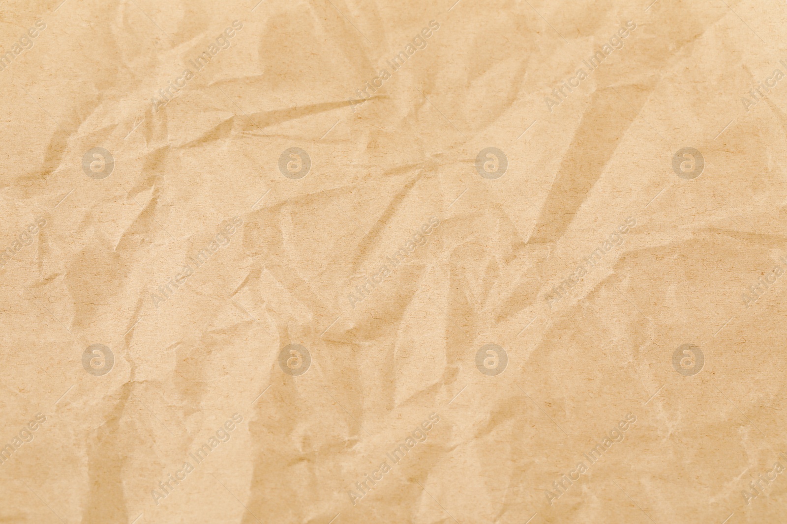 Photo of Crumpled kraft paper sheet as background, top view