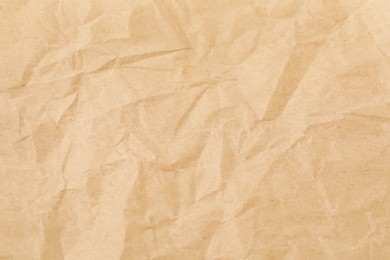 Photo of Crumpled kraft paper sheet as background, top view