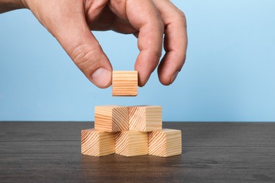 Photo of Woman with wooden cubes at table, closeup