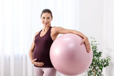 Photo of Beautiful pregnant woman with fitball at home