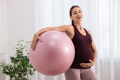 Beautiful pregnant woman with fitball at home