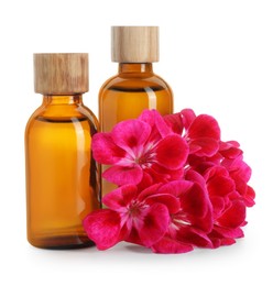 Photo of Geranium essential oil in bottles and beautiful flowers isolated on white