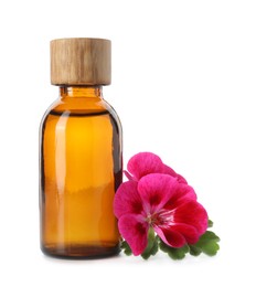 Photo of Geranium essential oil in bottle and beautiful flower isolated on white