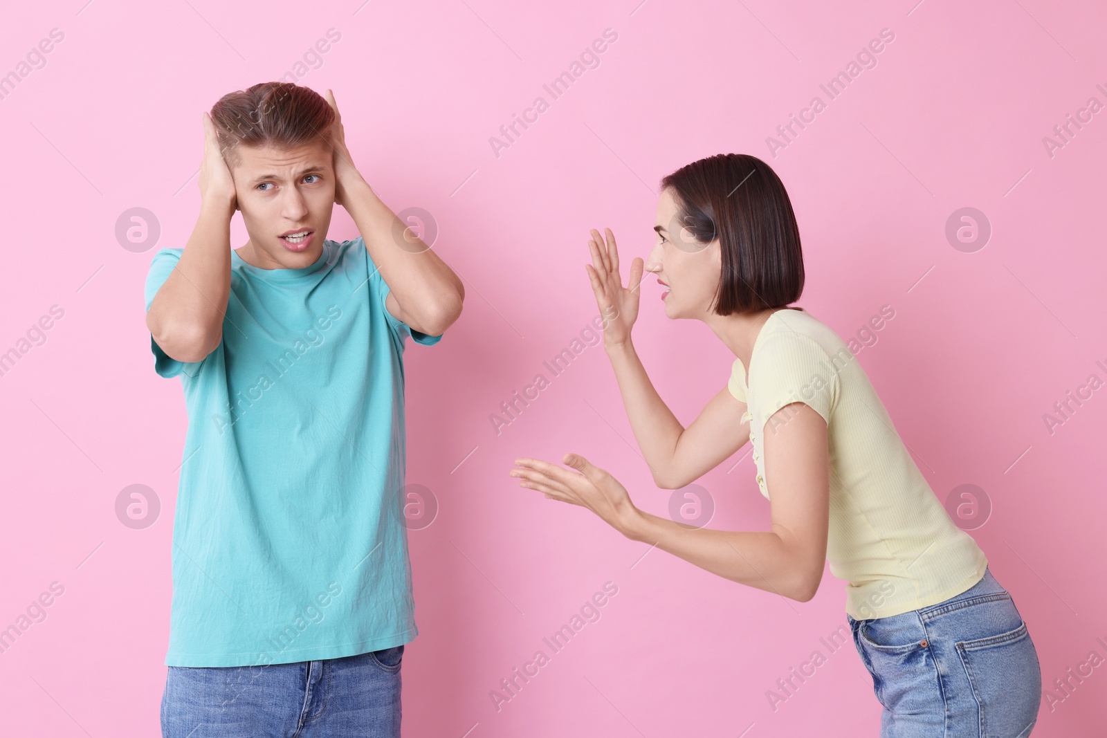 Photo of Emotional young couple arguing on pink background