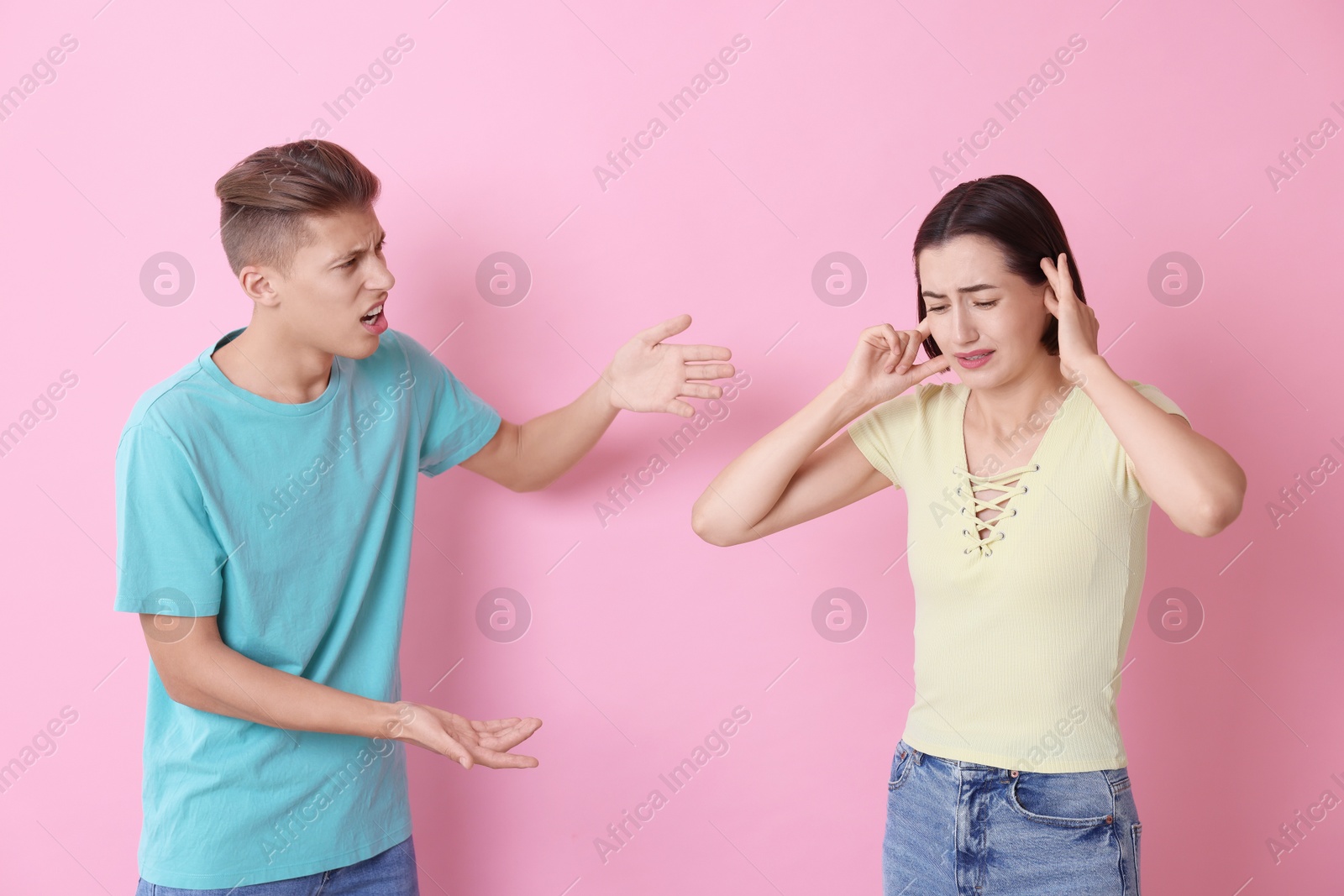 Photo of Emotional young couple arguing on pink background