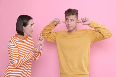 Photo of Emotional young couple arguing on pink background