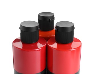 Photo of Red acrylic paints in bottles isolated on white