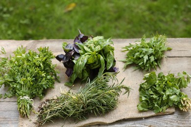 Photo of Different fresh herbs on wooden table outdoors