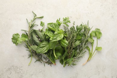 Photo of Different fresh herbs on light textured table, flat lay