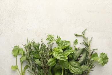 Photo of Different fresh herbs on light textured table, flat lay. Space for text