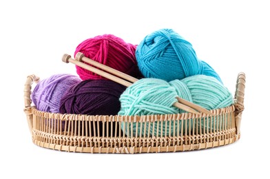 Many bright yarns and knitting needles in wicker basket isolated on white