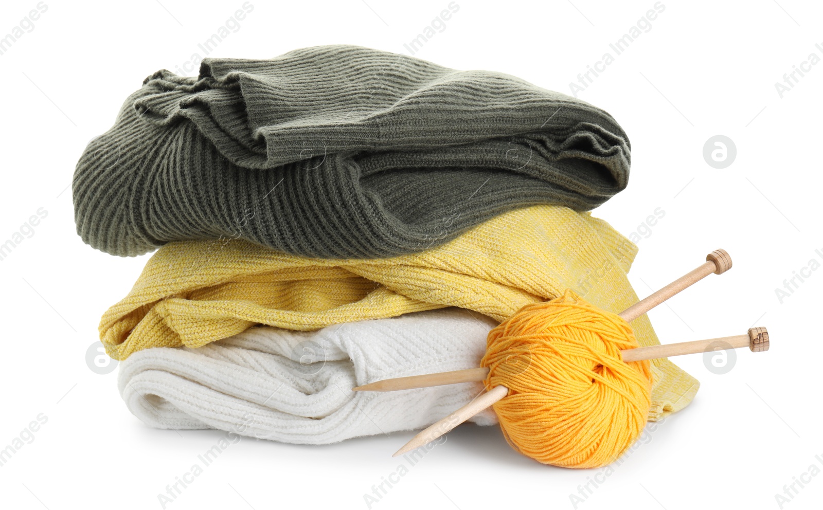 Photo of Ball of yarn with knitting needles and sweaters isolated on white