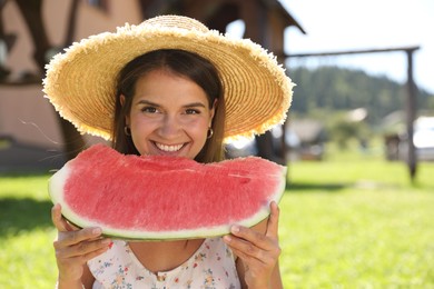 Happy woman with slice of juicy watermelon outdoors, space for text