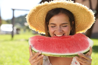 Photo of Happy woman eating fresh juicy watermelon outdoors