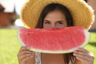 Woman with slice of juicy watermelon outdoors