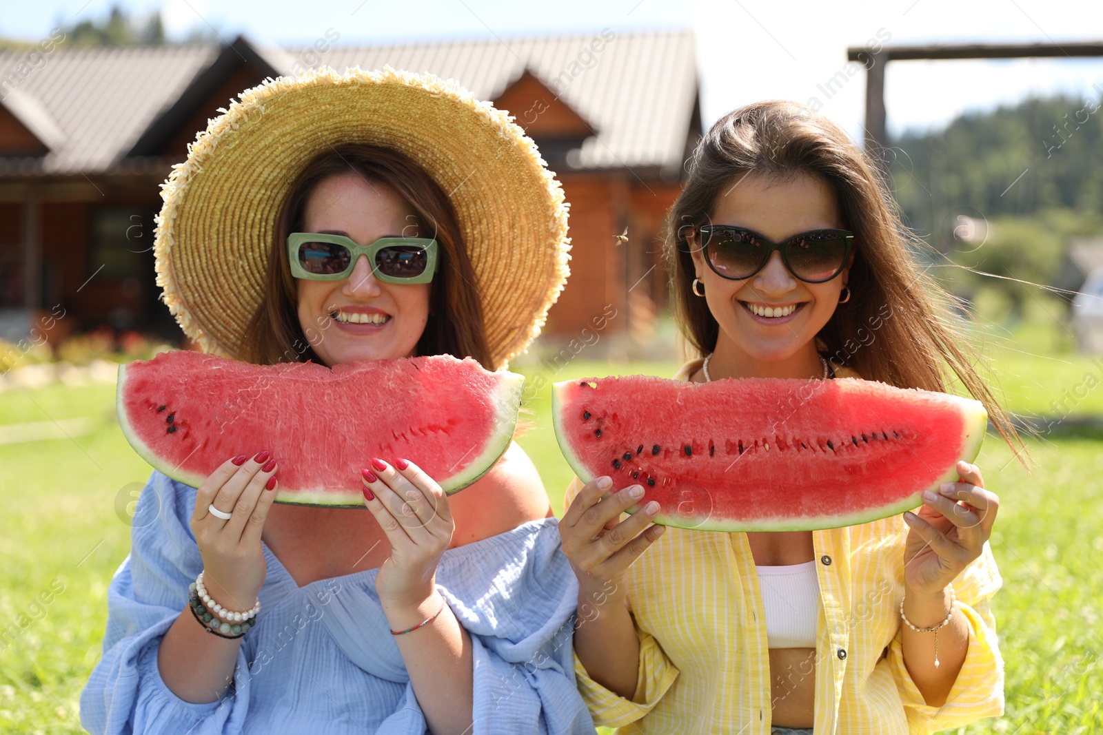 Photo of Happy women with slices of juicy watermelon outdoors