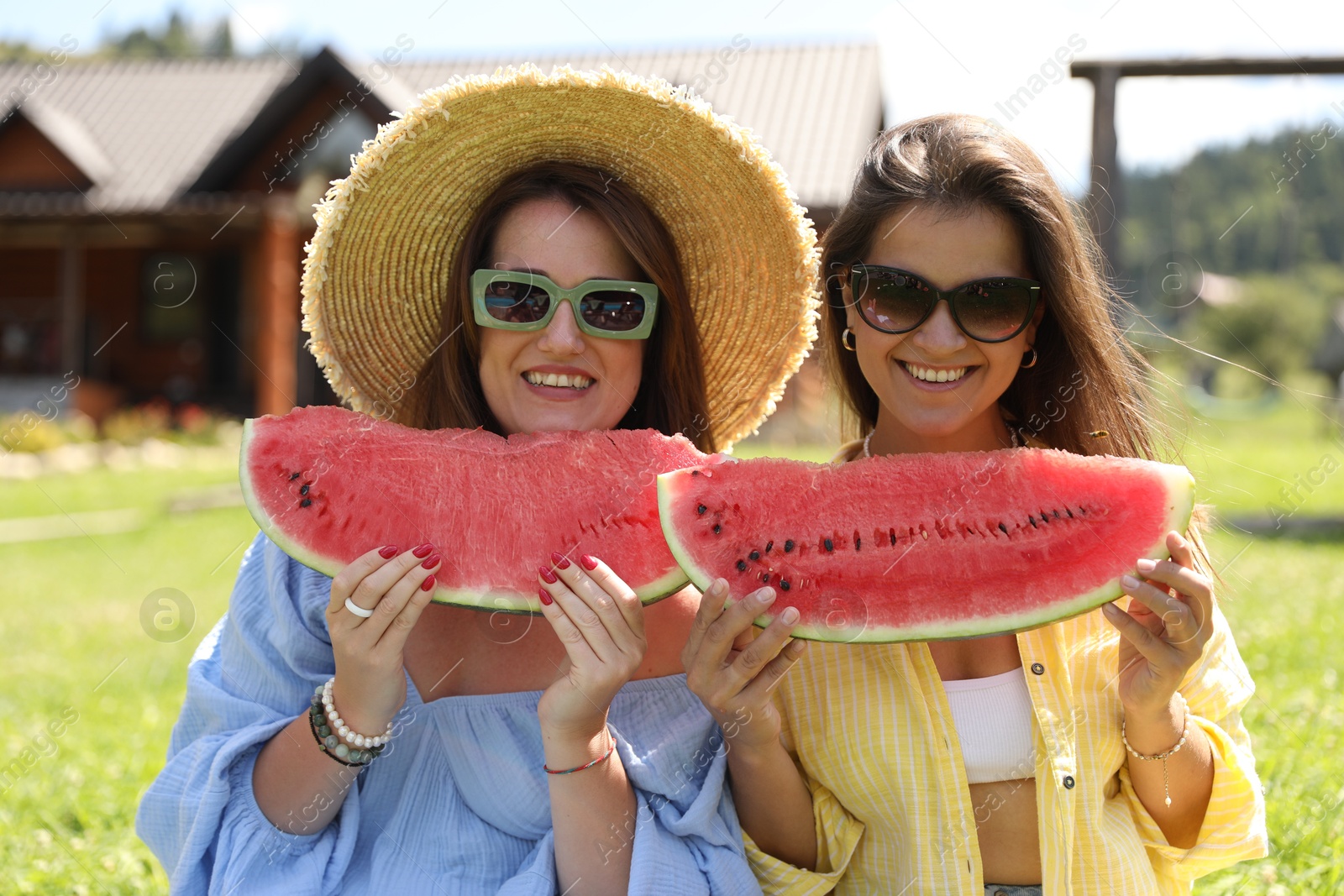 Photo of Happy women with slices of juicy watermelon outdoors