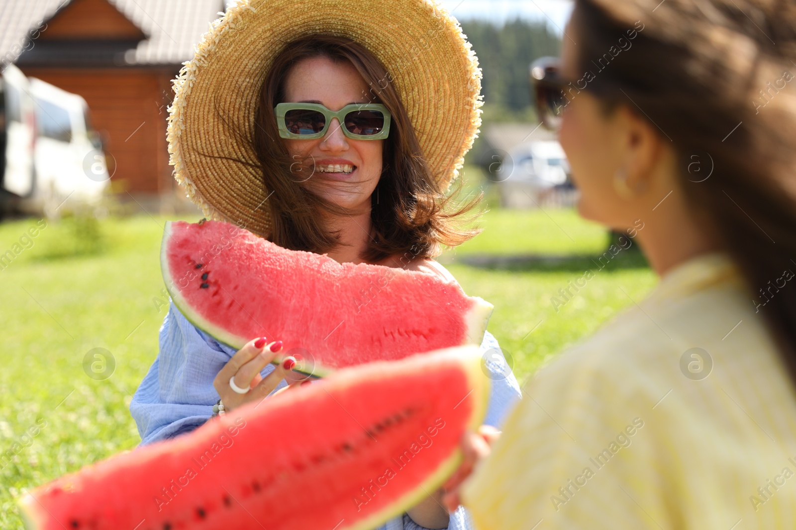 Photo of Women with slices of juicy watermelon outdoors