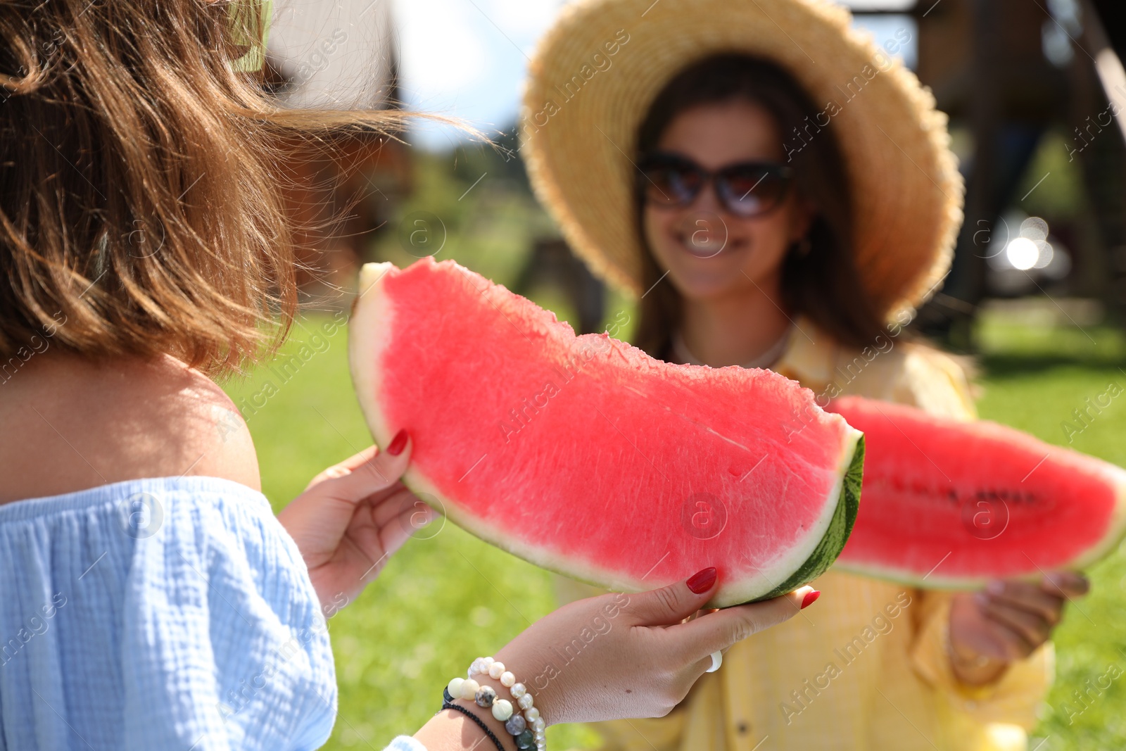 Photo of Women with slices of juicy watermelon outdoors